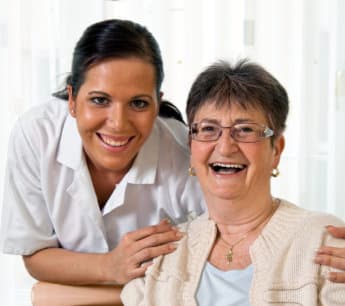 caregiver and elderly woman smiling